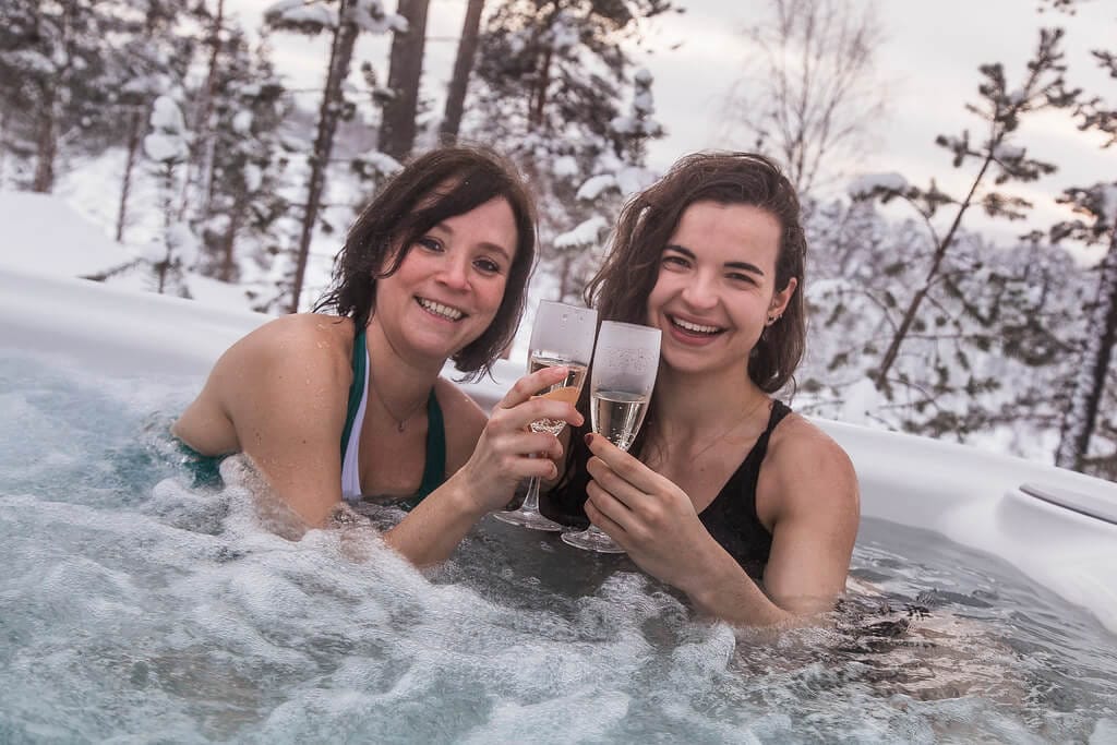 Aurora Village Finnland -  Zwei Frauen mit Sekt in Whirlpool